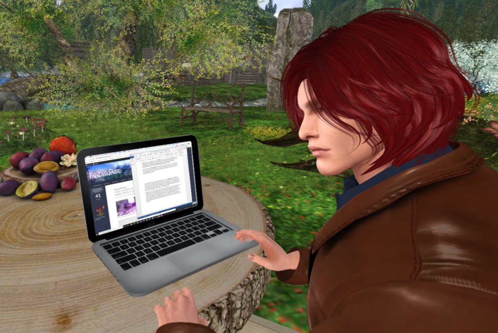Close up of Nathaniel, with a laptop on a rustic table in front of him. On the screen, a Word document and the Fantasy Faire website