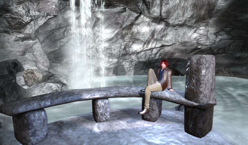 Nathaniel, sitting on a stone bench in front of a small pond, into which falls a waterfall